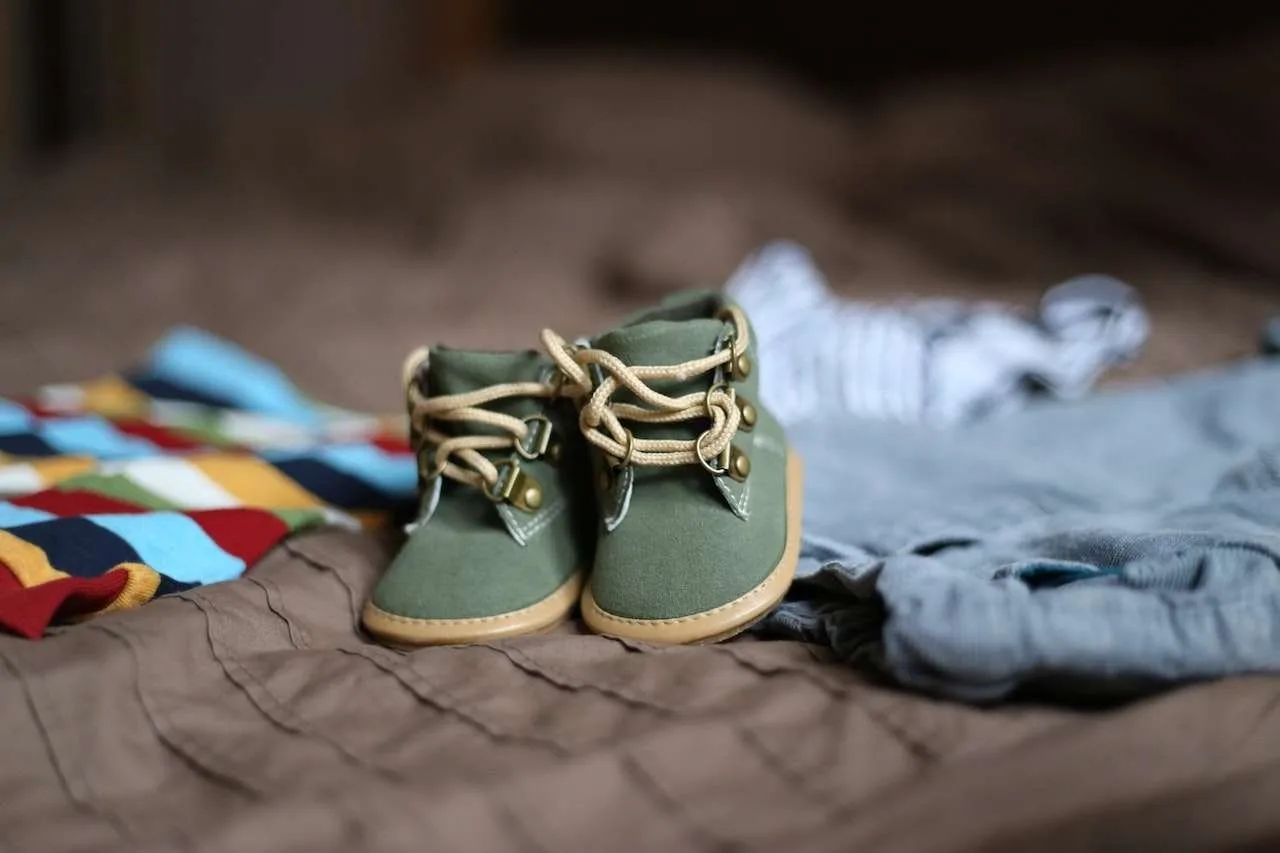 baby clothes sitting on bed