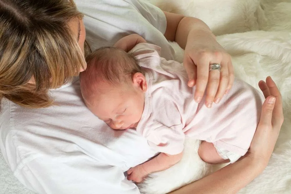 Baby sleeping on mother's belly