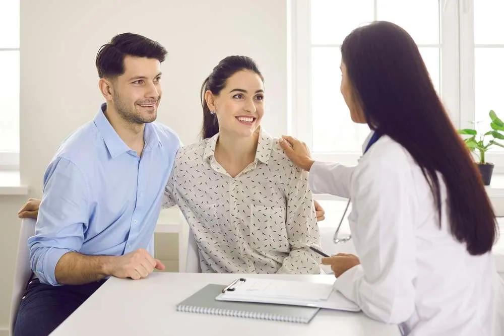 Happy young couple planning pregnancy and visiting their family practitioner together