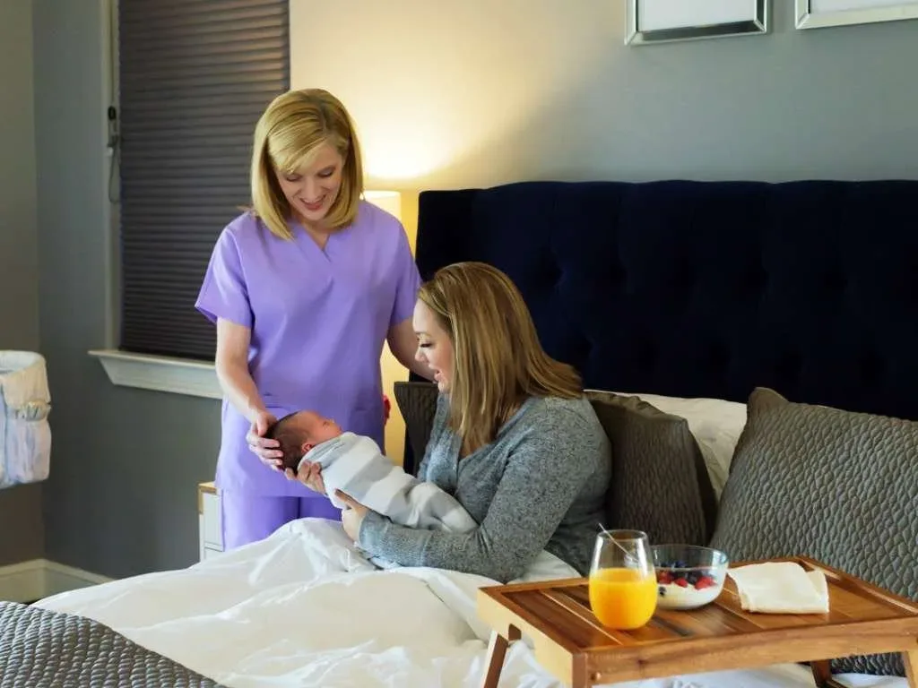 postpartum doula helping mother with baby