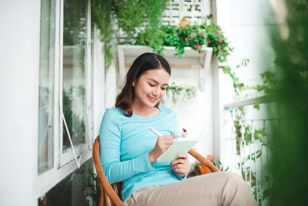 Beautiful asian woman at home writing and working with diary