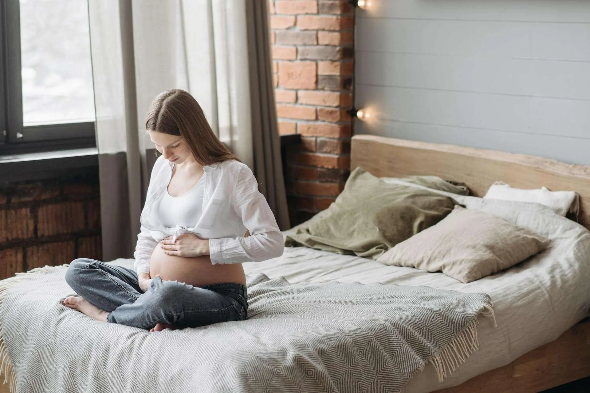 Pregnant mother sitting on bed